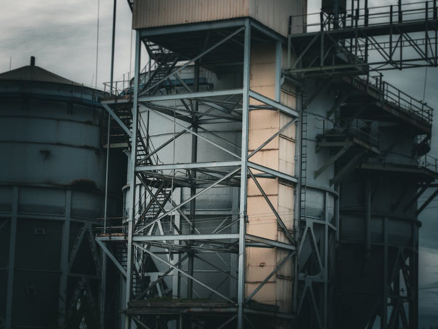 Primer plano de una estructura industrial de acero con escaleras y plataformas, que muestra su intrincada estructura metálica.
