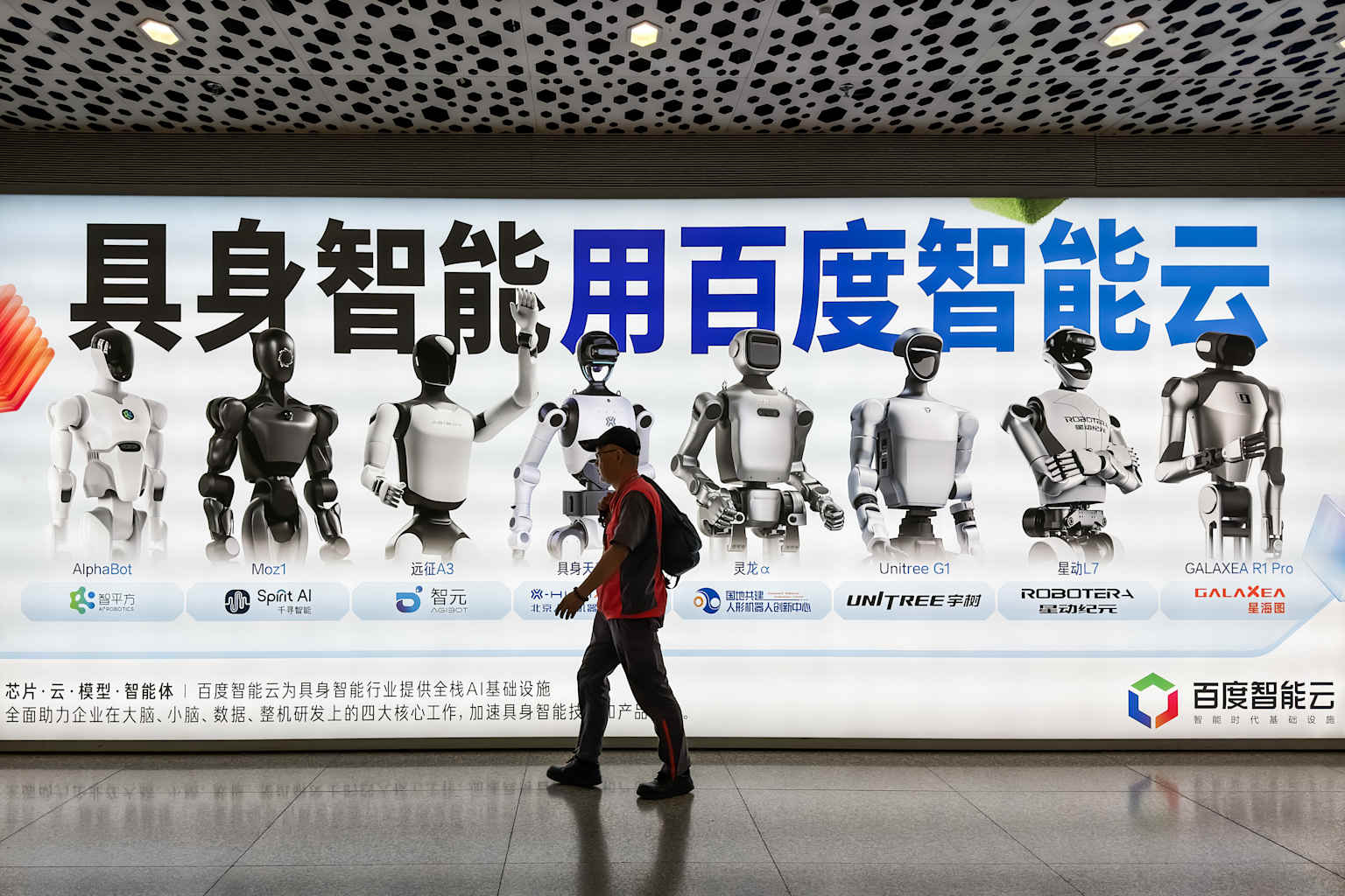 Un peatón camina frente a un anuncio publicitario de Baidu AI Cloud