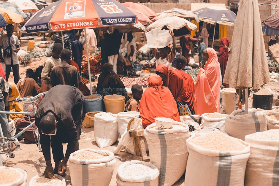 Una escena vibrante de vendedores y compradores en un mercado africano repleto de mercancías y actividad bulliciosa.
