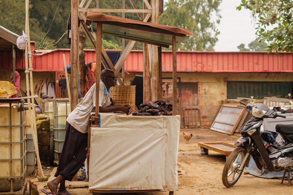 Un vendedor local en un mercado de Kaduna vende productos en un puesto rústico.