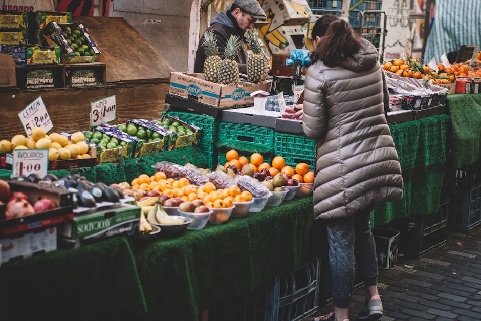 Mujer De Pie Delante De Una Variedad De Frutas Mostradas