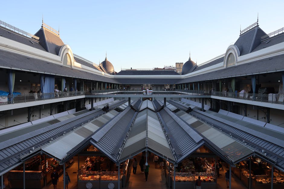 Un espacioso mercado interior con arquitectura clásica y techos altos durante el día.