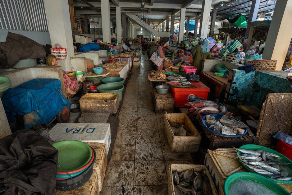 Mercado de pescado indonesio repleto de mariscos y productos de colores vibrantes, fotografiado en el interior.