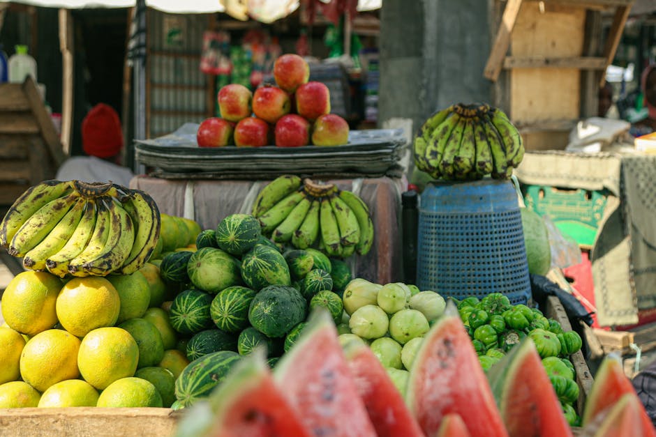 Una colorida exhibición de frutas frescas en un mercado al aire libre que muestra plátanos, manzanas y más.