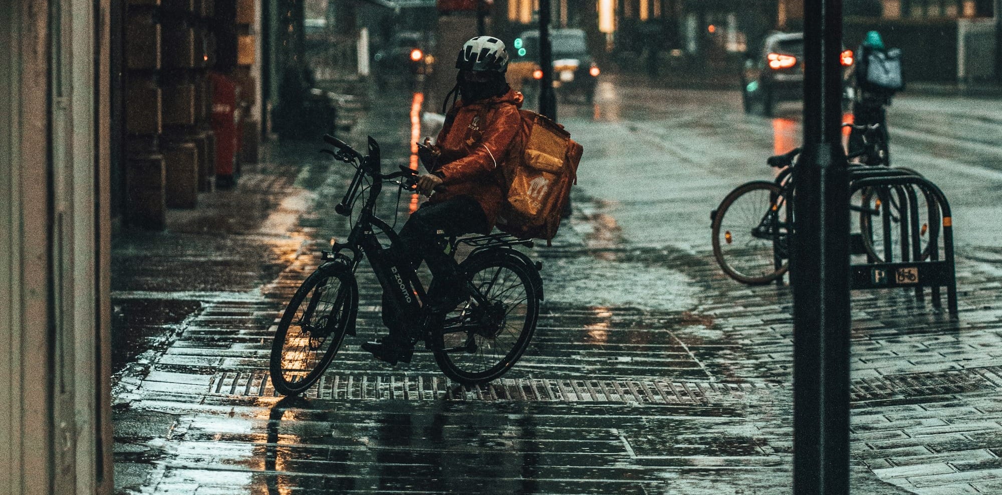 person in black jacket riding bicycle on sidewalk during daytime
