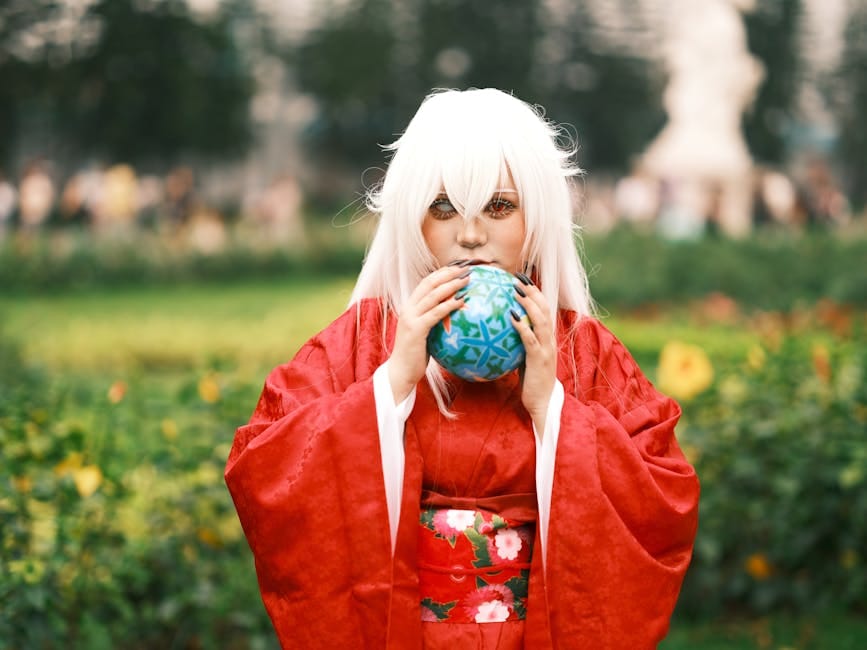 Una aficionada al cosplay, vestida con un kimono rojo y una peluca blanca, posa en un vibrante jardín vietnamita.