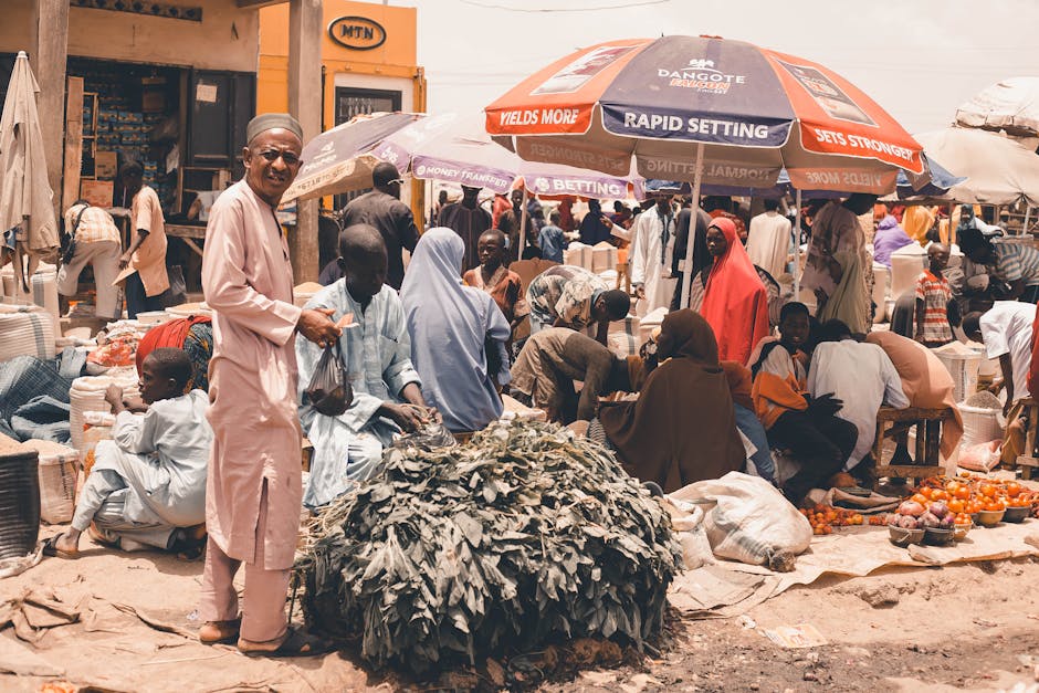 Un bullicioso mercado al aire libre con un grupo diverso de personas que compran y venden productos en África.