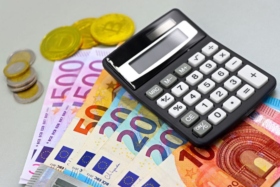 Imagen de billetes y monedas de euro y una calculadora para planificación financiera. Ideal para temas financieros.
