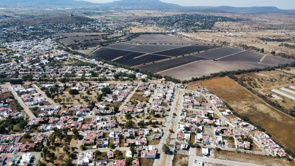 Vista aérea panorámica de un pueblo y campos en el campo mexicano en un día soleado.