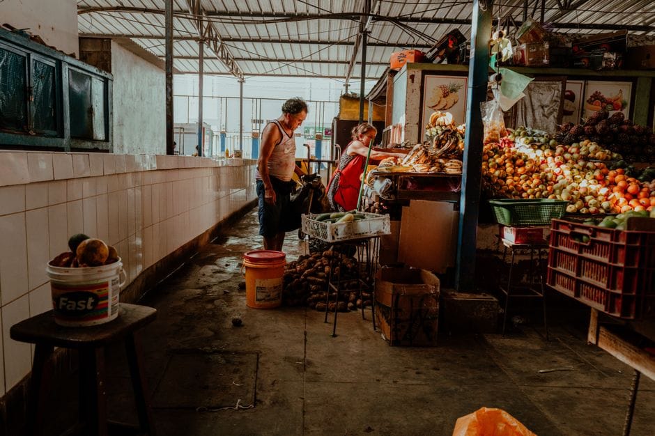 Mercado animado en Pacasmayo, Perú, con productos frescos y vendedores locales.