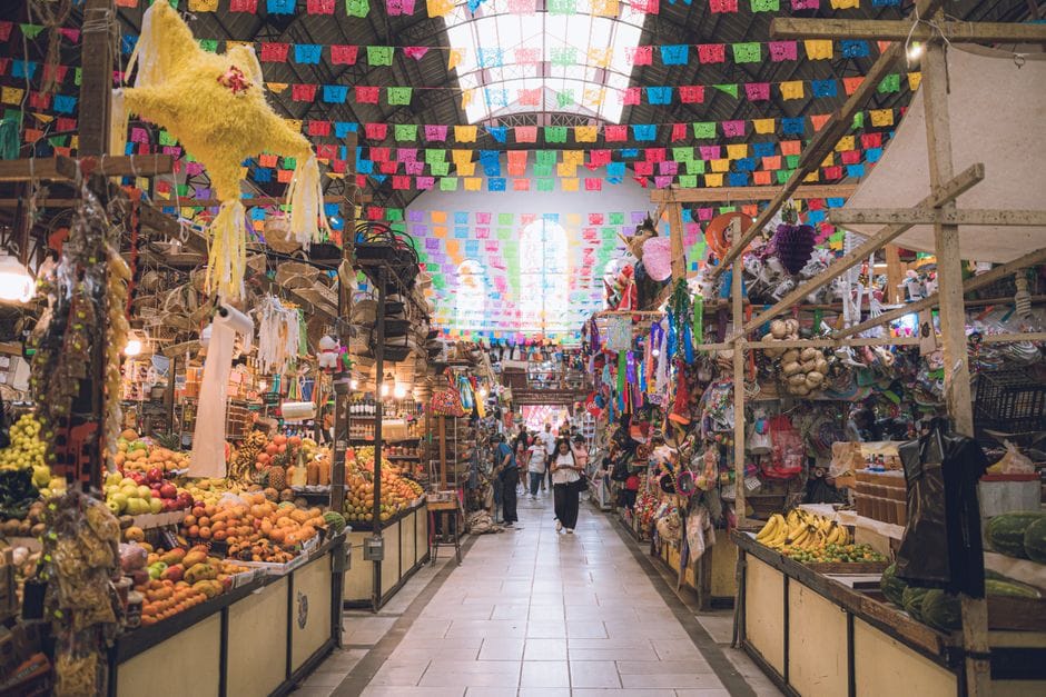 Un mercado colorido en Guanajuato, México, rebosante de productos frescos y decoraciones tradicionales.
