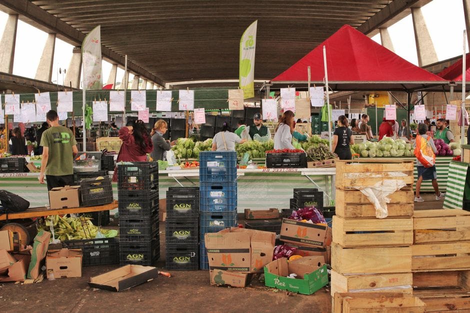 Vibrante escena de mercado interior con productos frescos y gente comprando en São Paulo, Brasil.