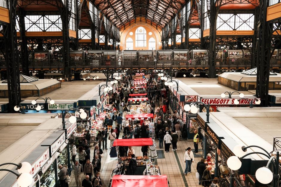 Explora el vibrante Mercado Central de Budapest, repleto de compradores y vendedores capturados desde arriba.
