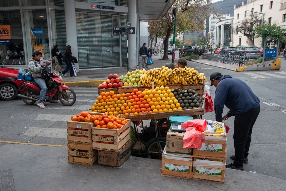 Puesto de frutas vibrante en una esquina de Salta, Argentina, con plátanos, naranjas y aguacates frescos.