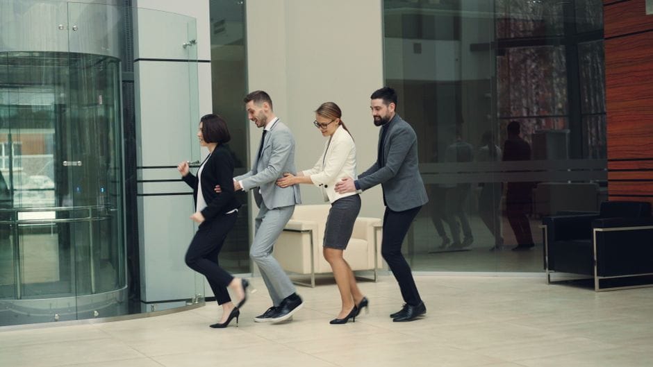 Los profesionales de negocios disfrutan de la diversión de la conga en un entorno de oficina moderno.
