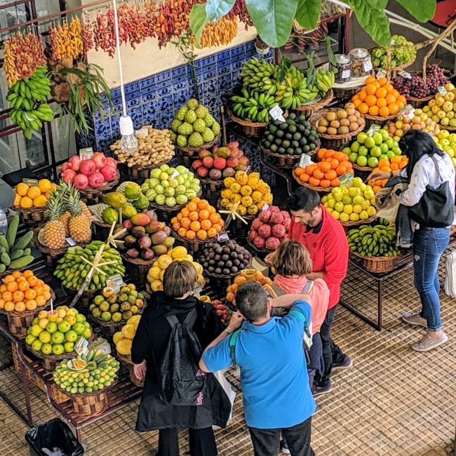 Vibrante mercado de frutas en Funchal, Madeira, que muestra diversas frutas tropicales y productos locales.
