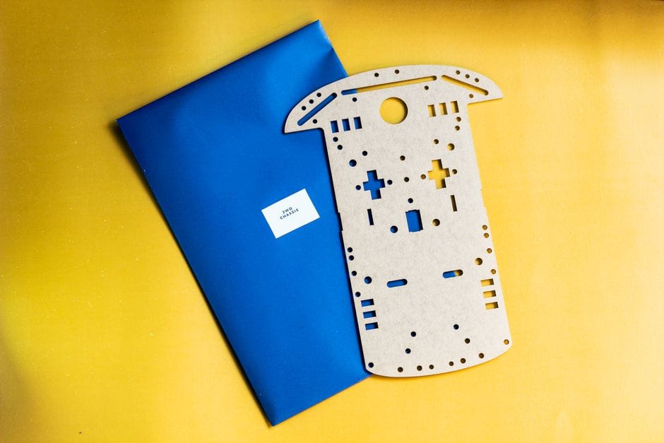 Componente de kit de robótica de madera sobre un fondo amarillo y azul vibrante.