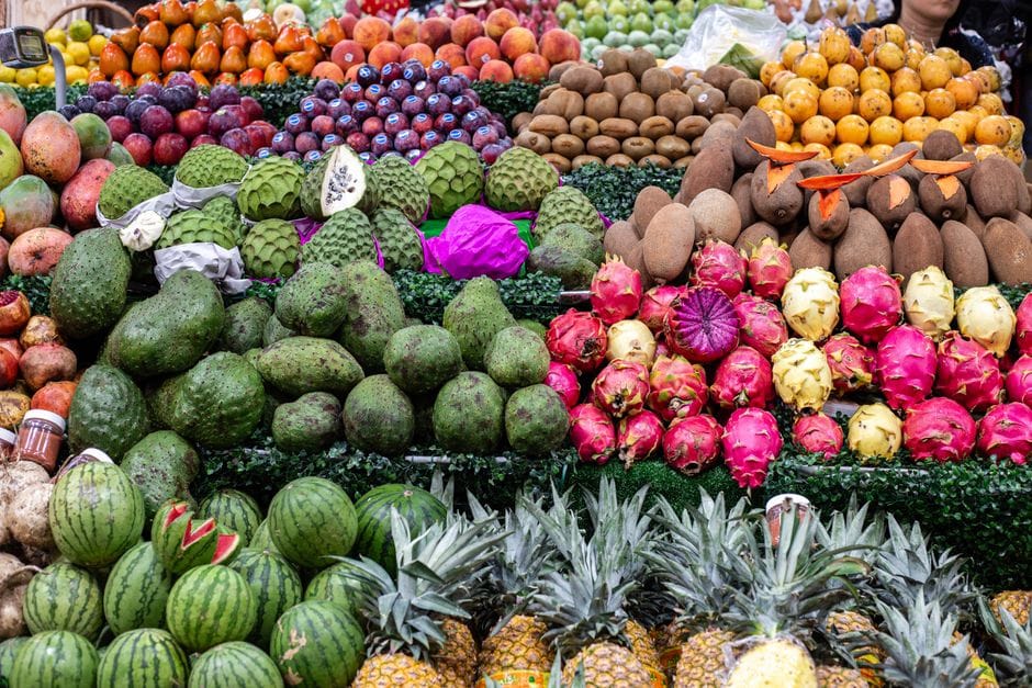 Gran variedad de frutas exóticas y tropicales en un mercado mexicano, que exhibe productos locales.