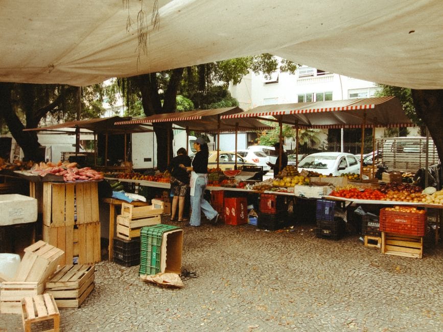 Animado mercado al aire libre en Río de Janeiro, con productos frescos bajo un toldo.