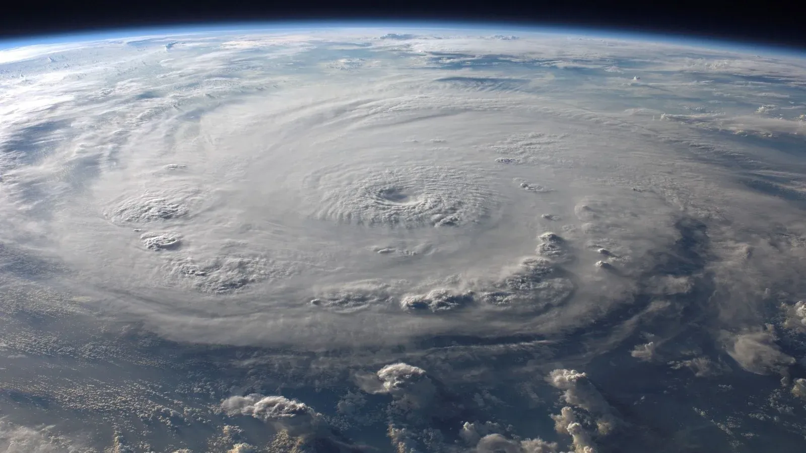 A stunning aerial view of Earth with a massive swirling hurricane, highlighting meteorological beauty.
