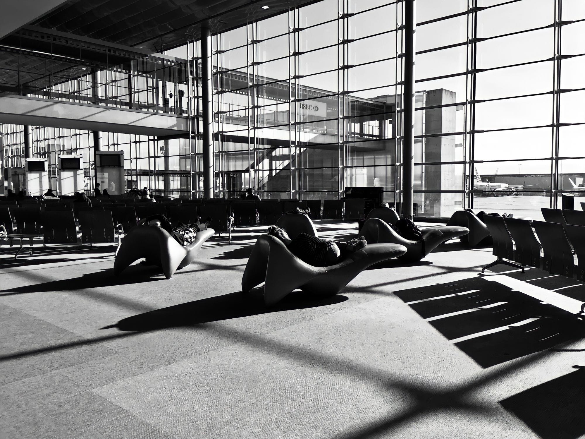 A modern airport lounge in Roissy-en-France, France, captured in monochrome with unique seating arrangements.