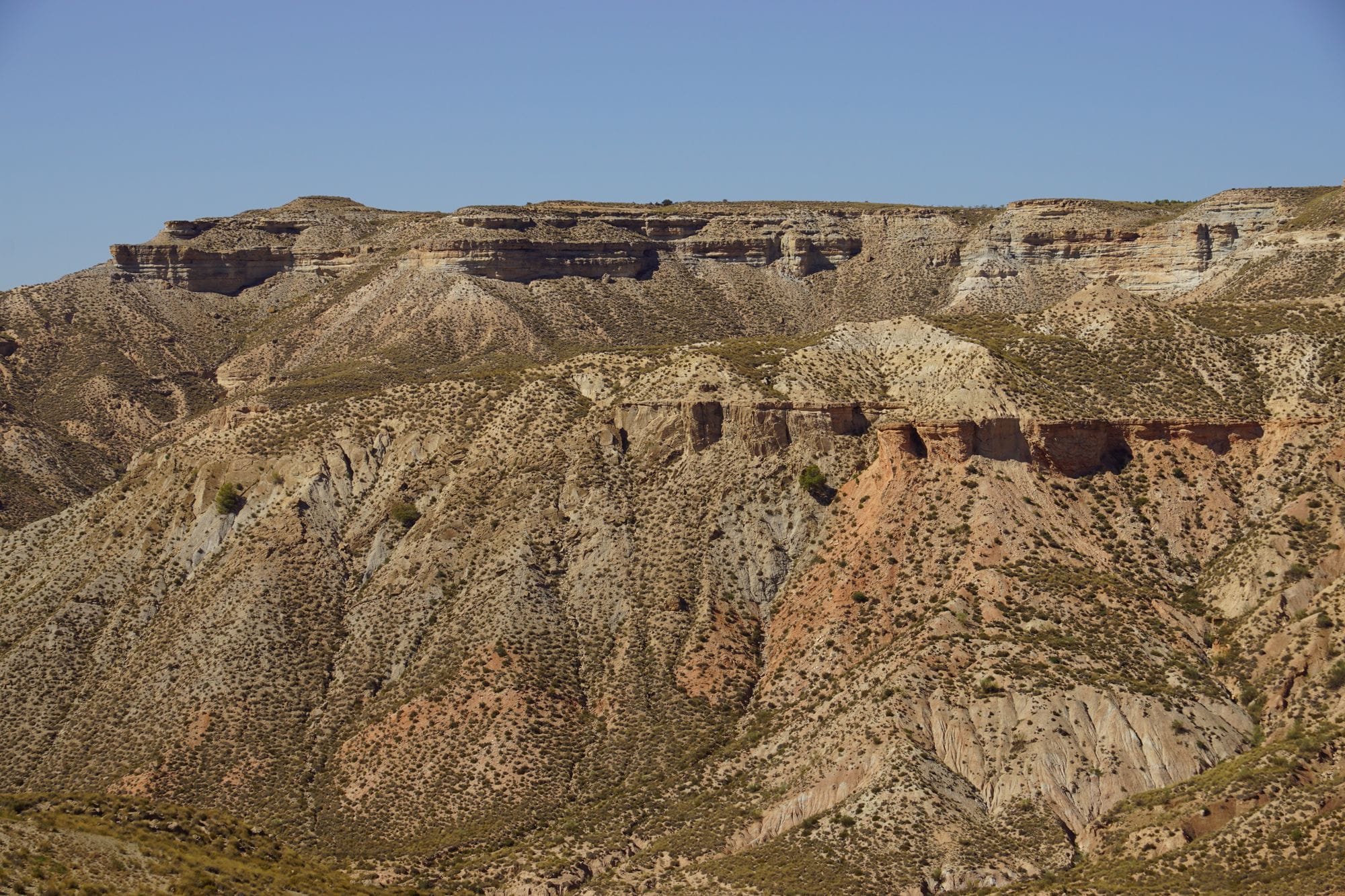 A breathtaking view of rugged mountains in Spain under a clear blue sky.