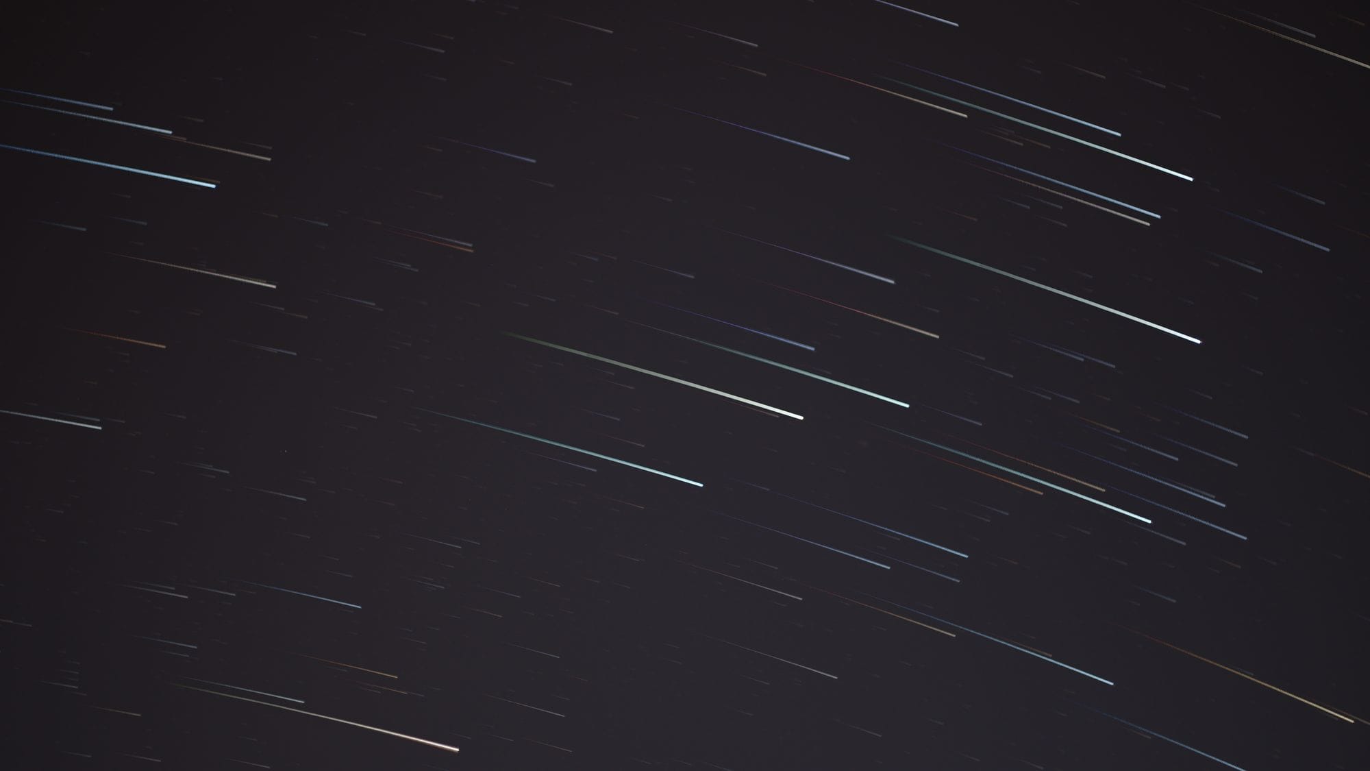 A mesmerizing long exposure photograph capturing streaking stars in the night sky.