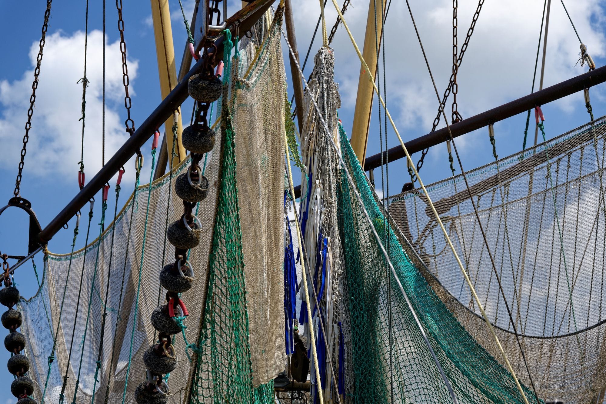 Close-up of fishing nets hanging from a boat mast in Krummhörn, Germany.