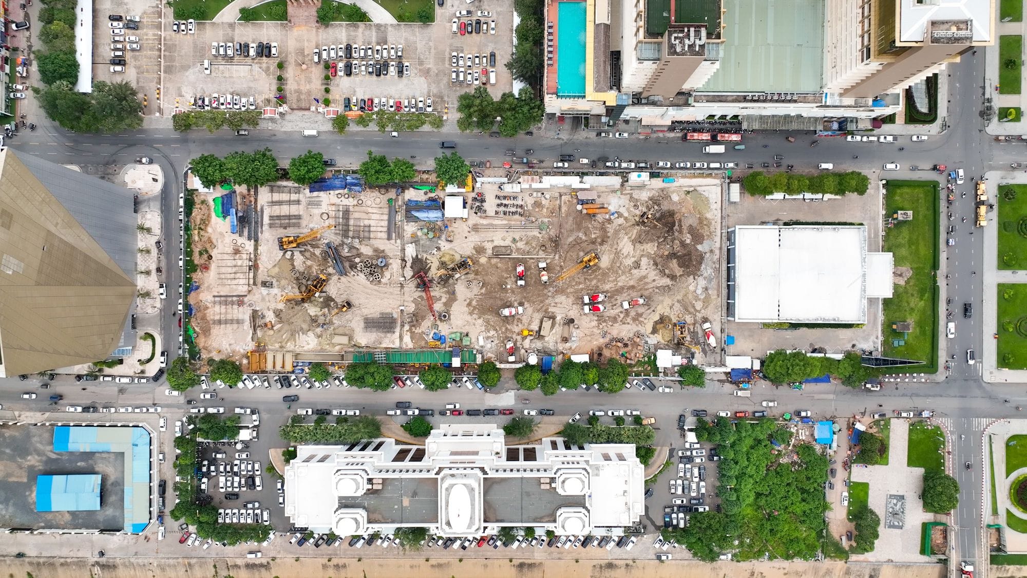 Aerial view of a bustling construction site in Phnom Penh, surrounded by urban structures.