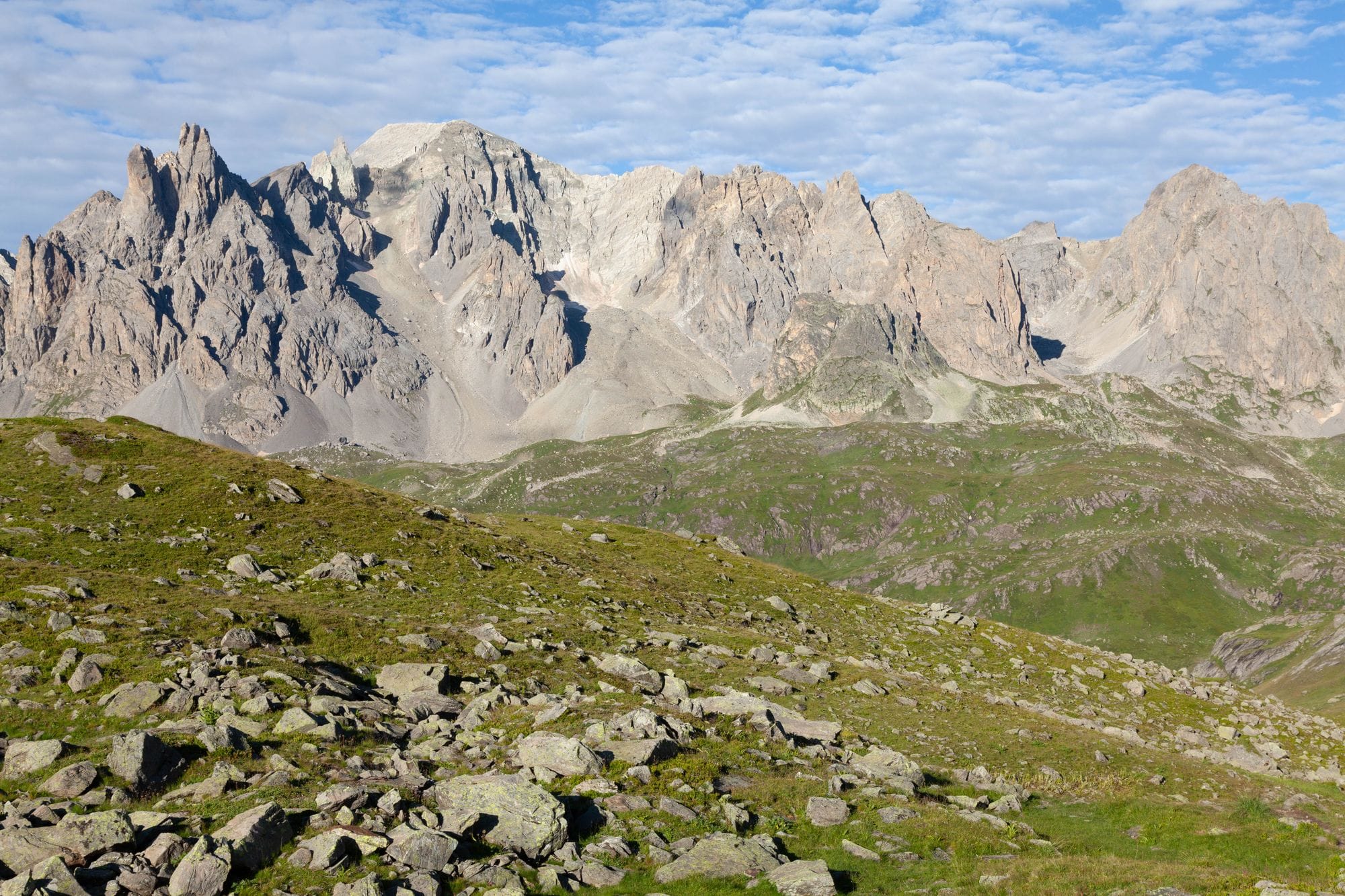 Alpine landscape with rocky mountains and green fields in Briançon, Provence-Alpes-Côte d'Azur, France.