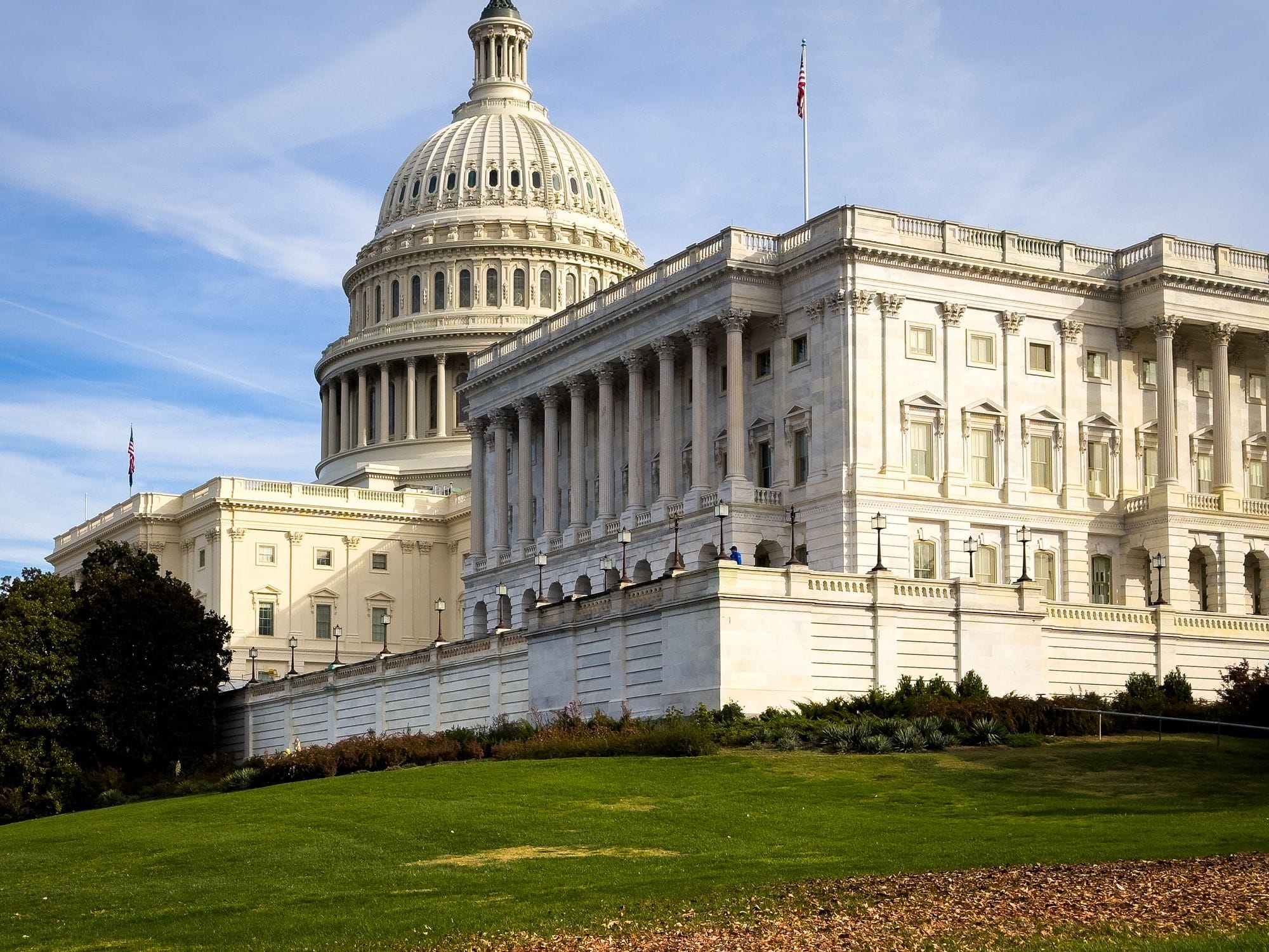 A picturesque view of the US Capitol Building in Washington, DC, under a clear sky.