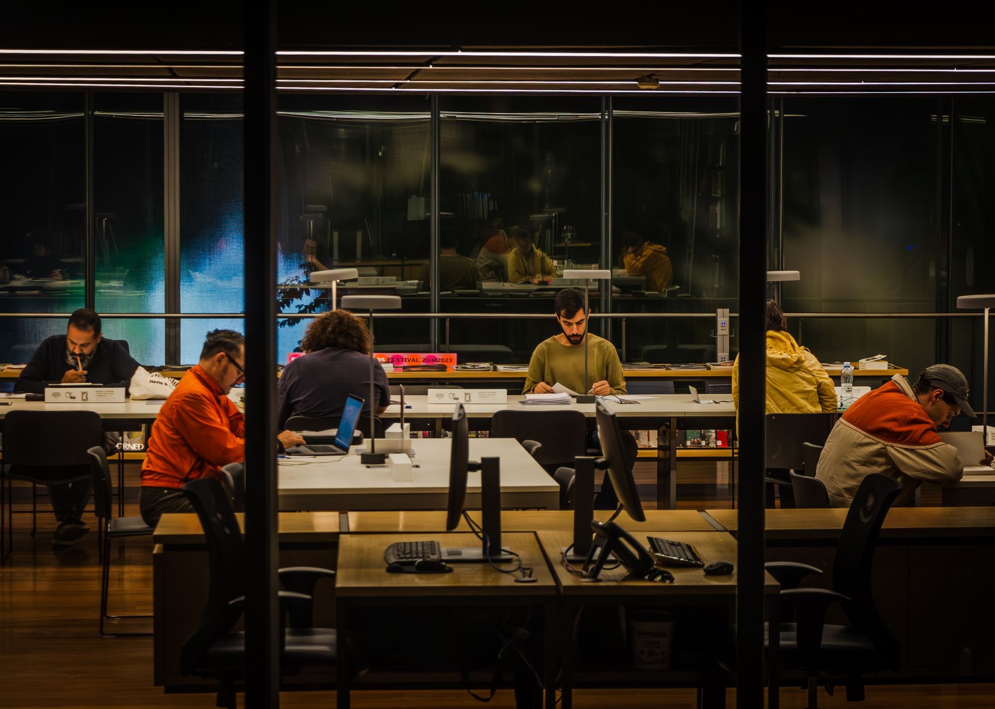 Students focused on studying in a modern São Paulo library at night.