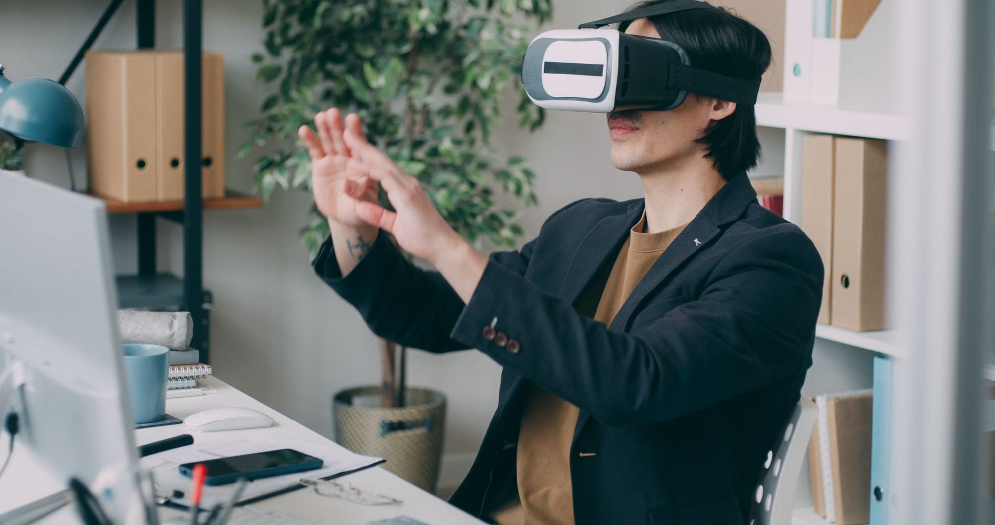A man in an office environment using a virtual reality headset, engaging with VR content.