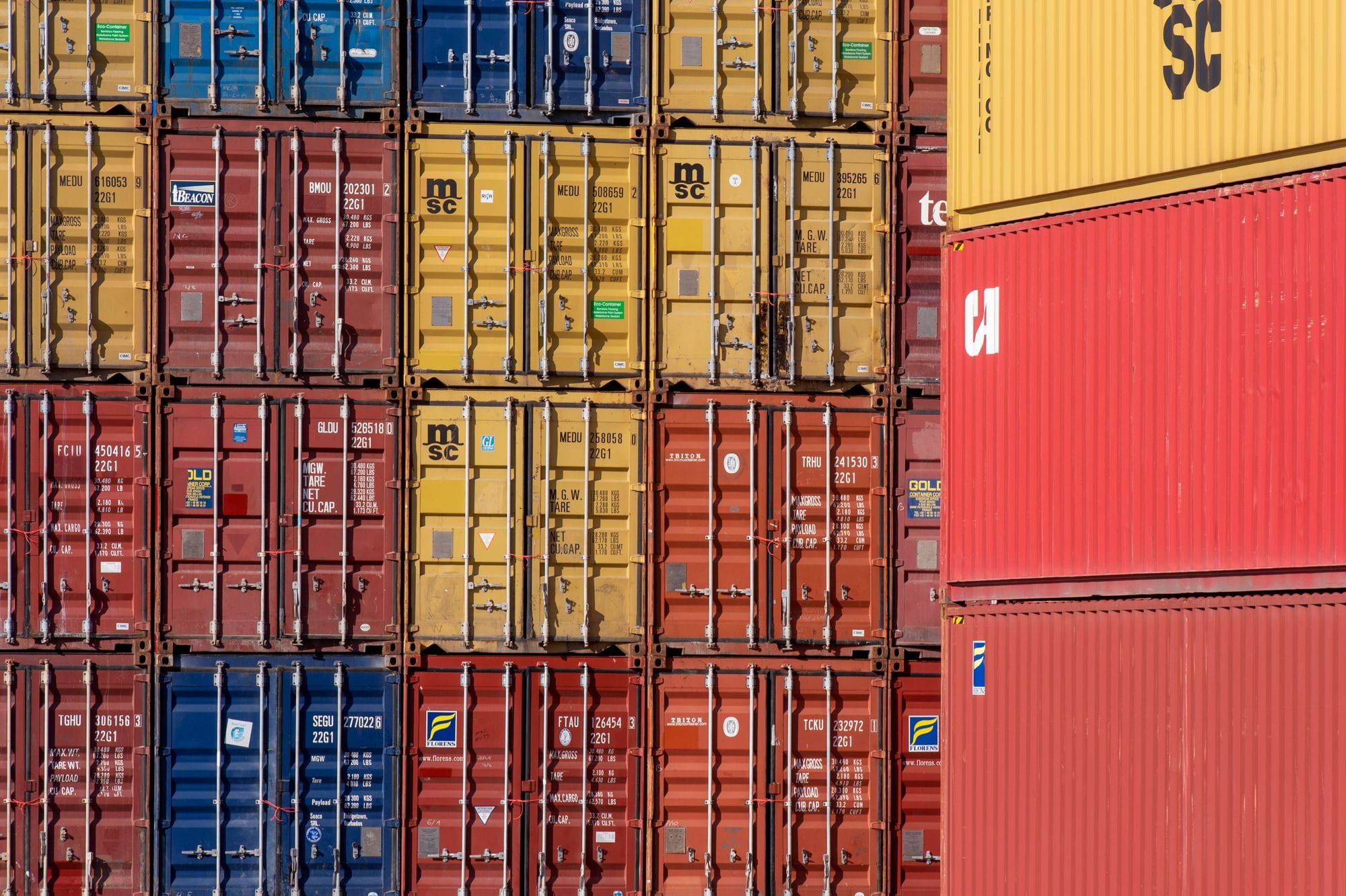 Colorful shipping containers stacked in a port for transport logistics.