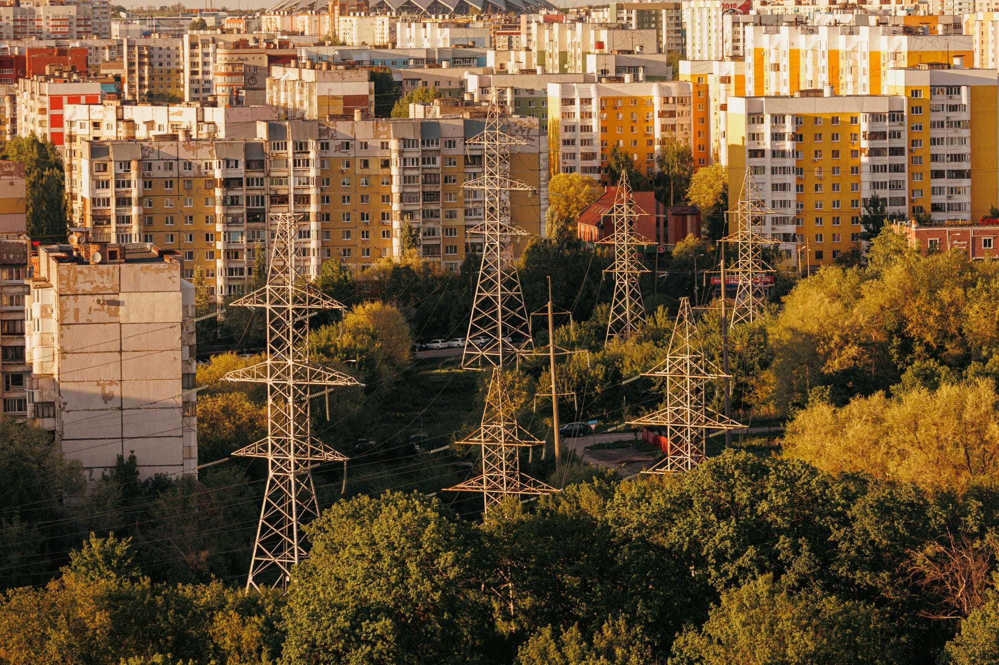 Aerial view of urban cityscape with high-voltage power lines and apartment buildings in autumn.