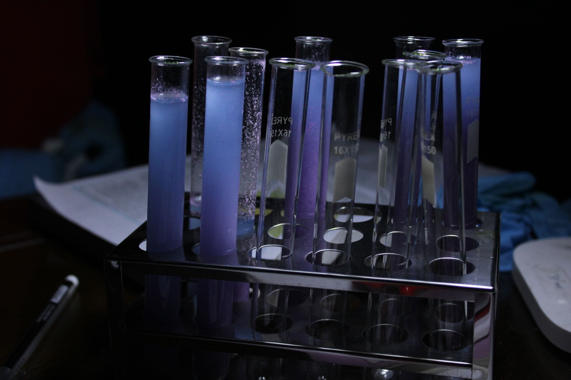 A vivid array of purple solutions in test tubes during a chemical experiment.