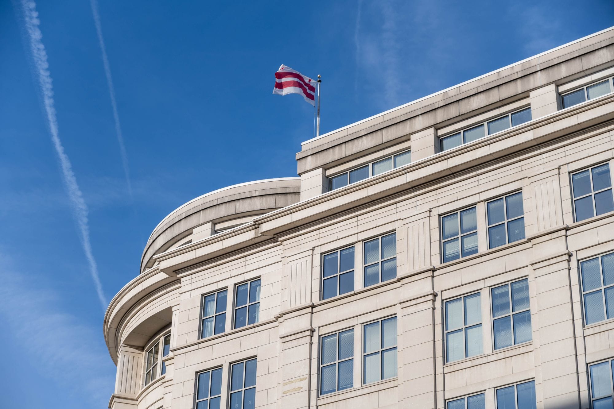 Exterior of a building in Washington DC with District of Columbia flag waving.