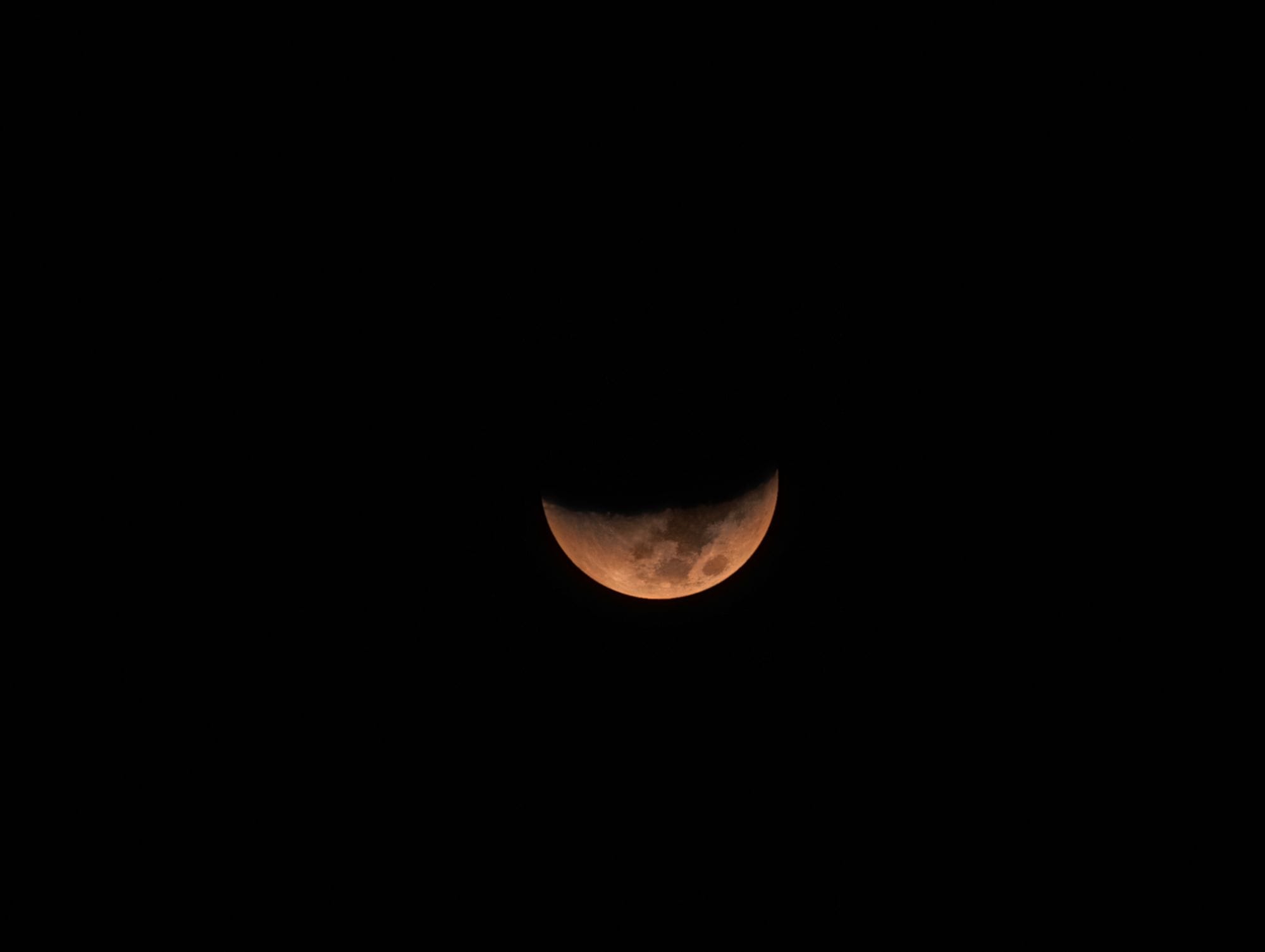 Captivating image of a partial lunar eclipse against a black sky, showcasing the moon's surface.