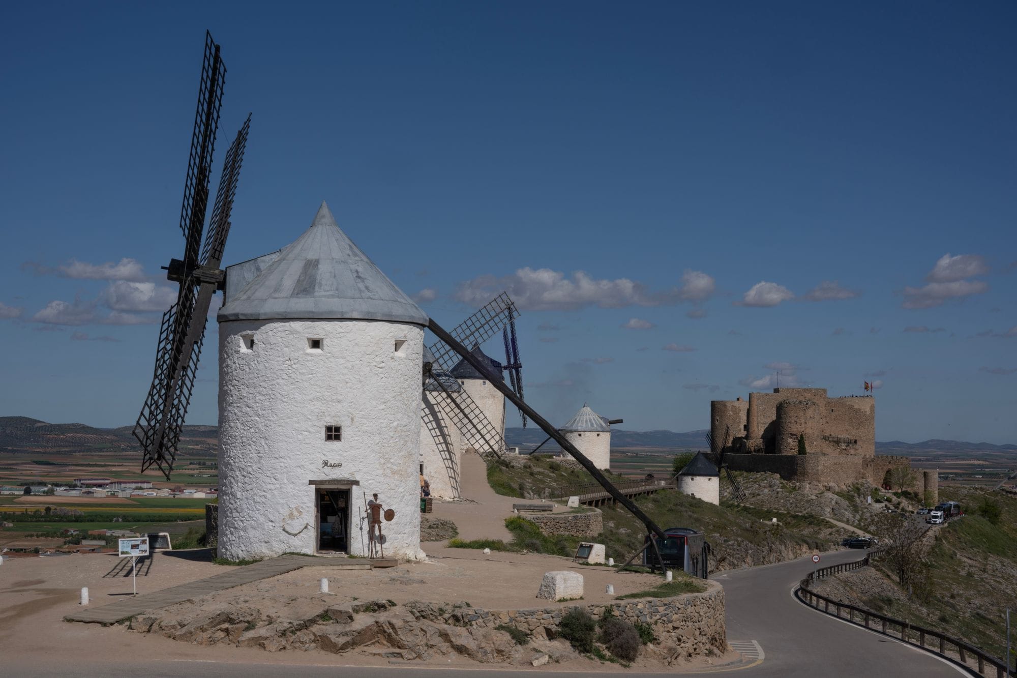 Scenic view of historic windmills and castle in Consuegra, Spain.