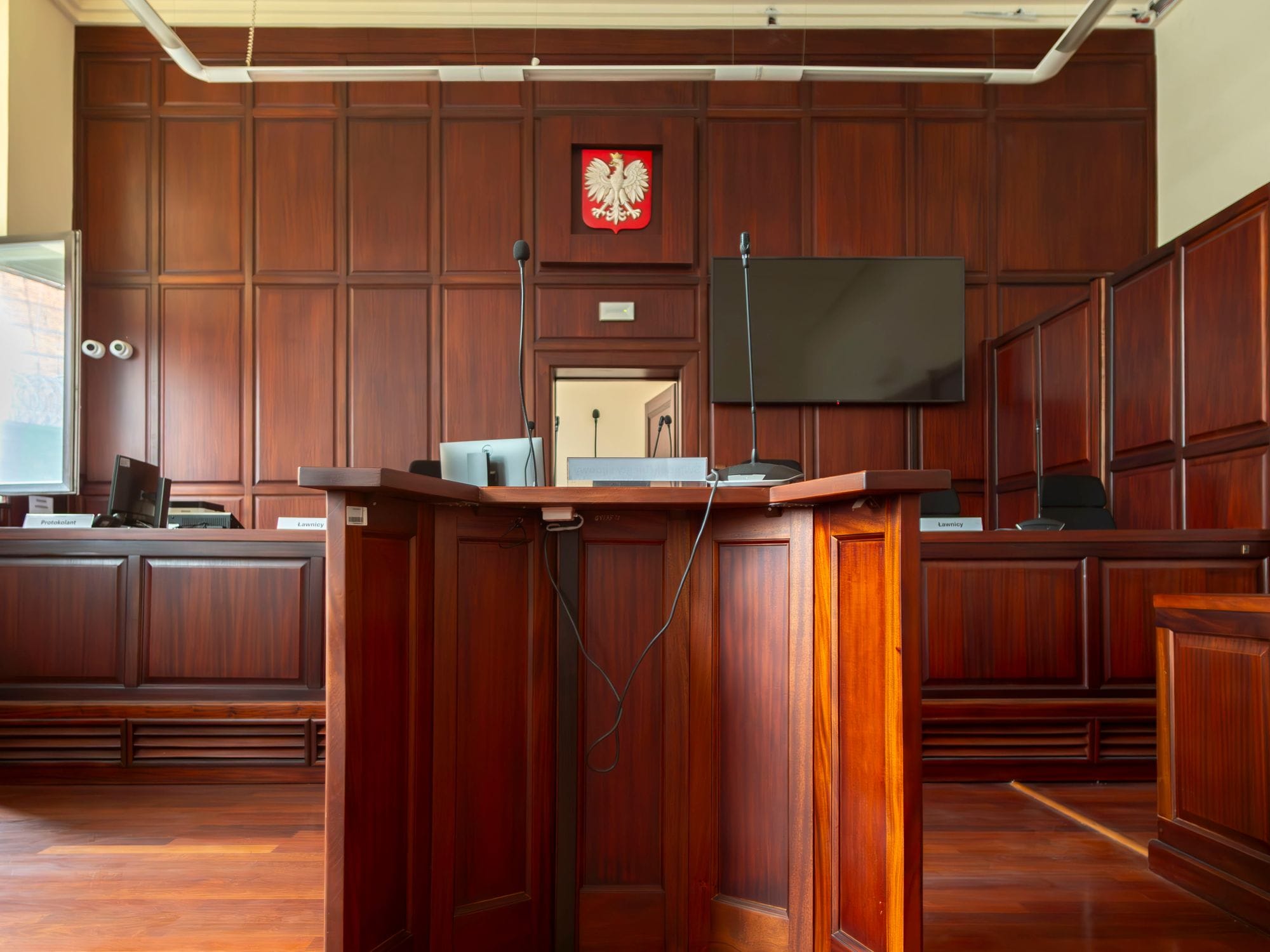 A detailed view of a courtroom interior in Wrocław, Poland, showcasing the judge's bench and national emblem.