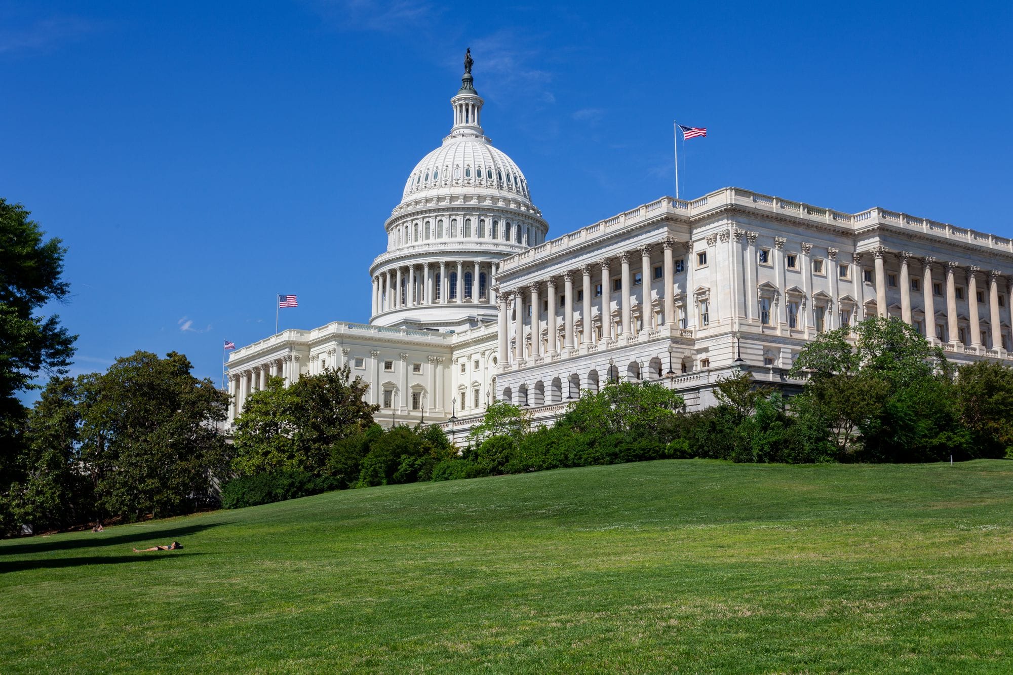 Stunning photo of the United States Capitol under a clear blue sky, showcasing neoclassical architecture.