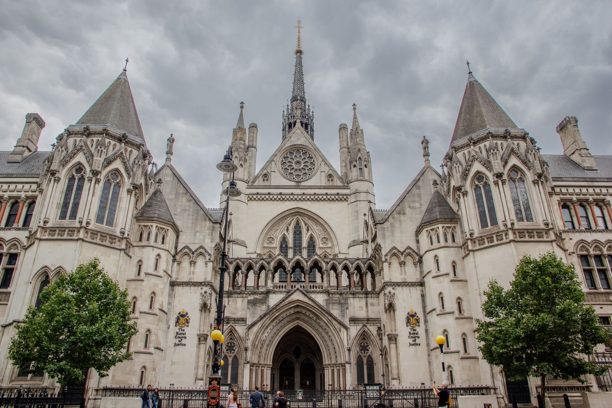 Exterior of the Royal Courts of Justice in London with cloudy skies.