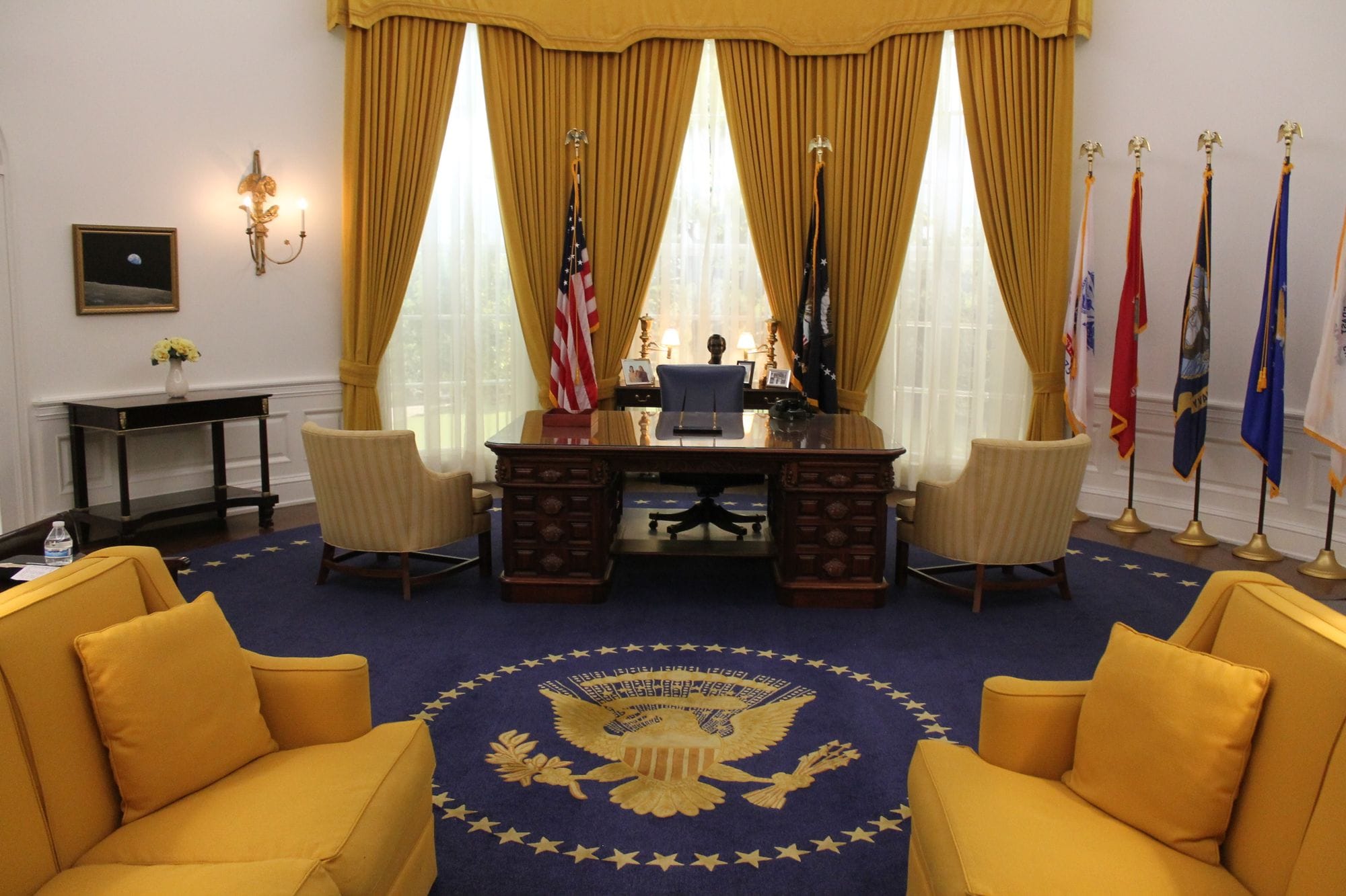 Interior of a presidential office showcasing elegant design with flags and majestic furnishings.
