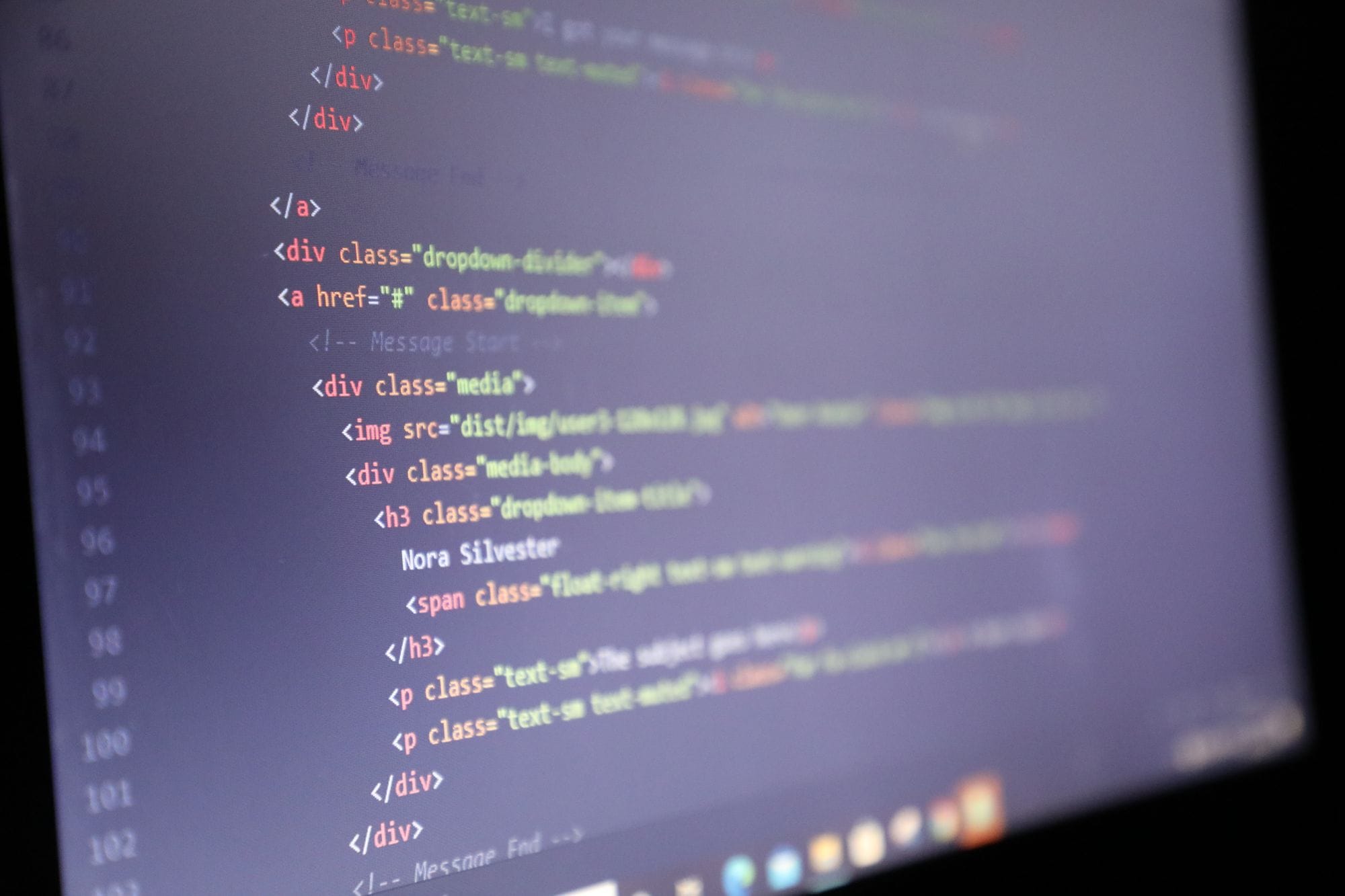 Illuminated HTML code displayed on a computer screen, close-up view.