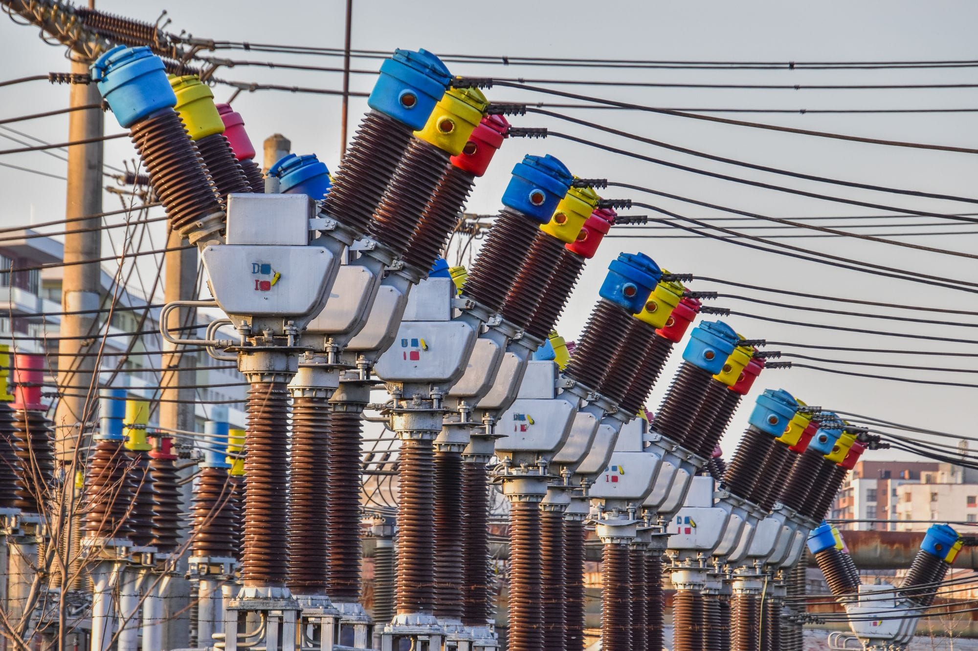 Multiple colorful electrical transformers at an outdoor power station under the daylight.