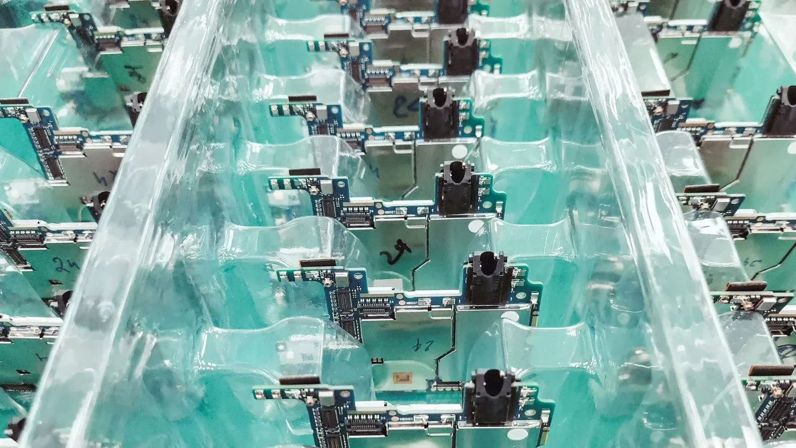 Detailed view of organized electronic circuit boards in a production setting.