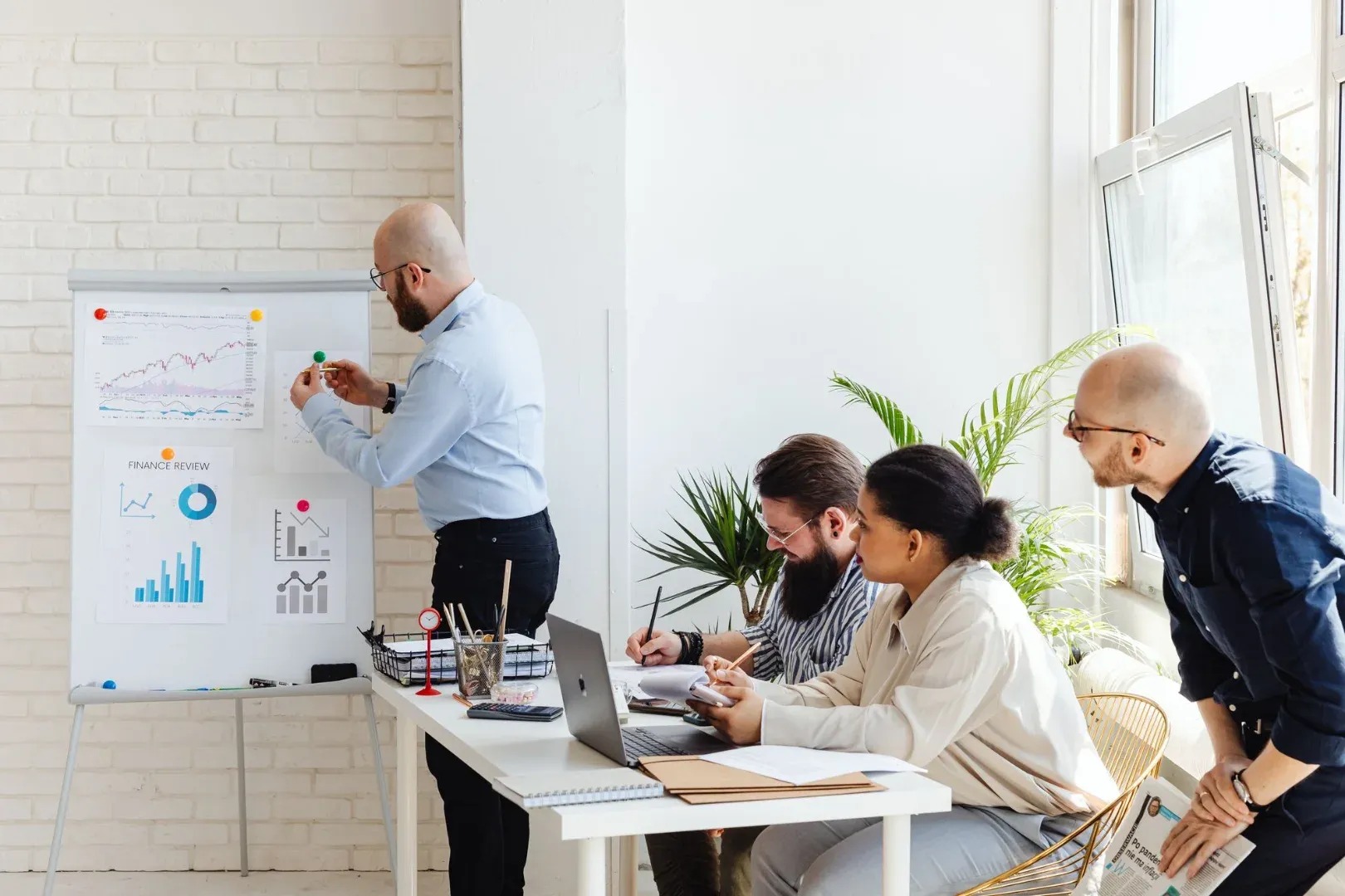 A diverse group of professionals discussing financial data in a modern office setting.