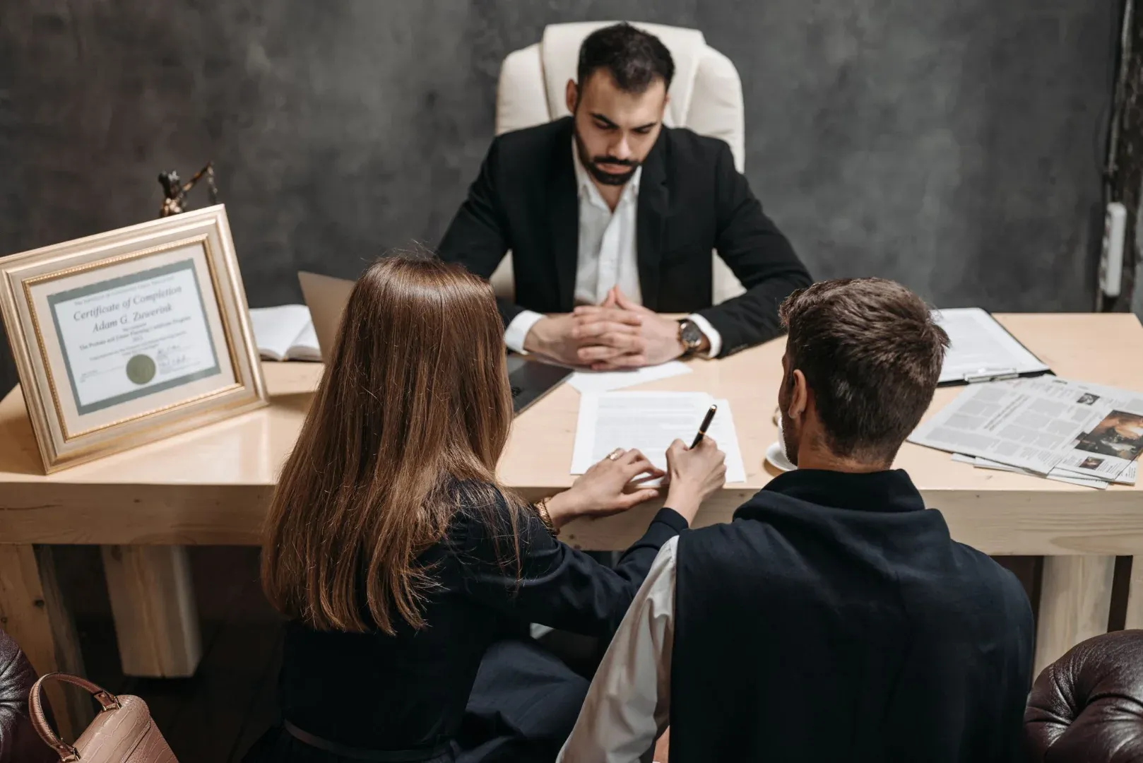 A lawyer discusses legal documents with clients in an office setting.