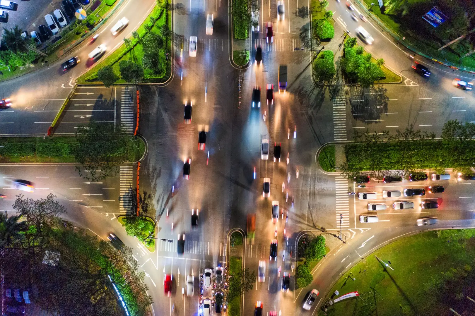 Aerial view of a bustling night intersection in Banten, Indonesia. Vibrant city traffic and illuminated roads.