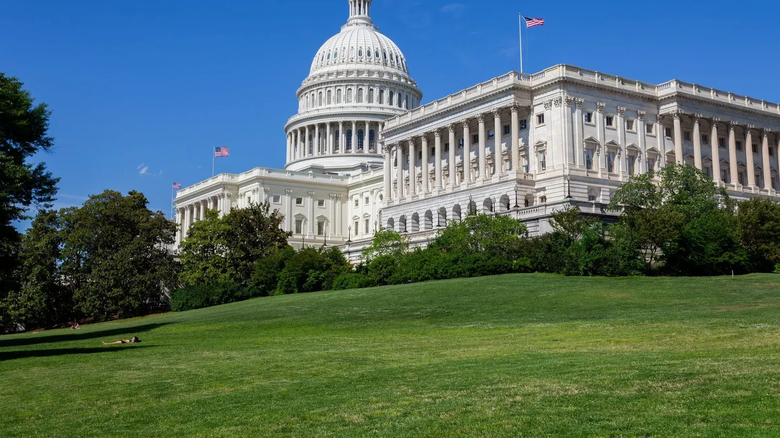 Stunning photo of the United States Capitol under a clear blue sky, showcasing neoclassical architecture.